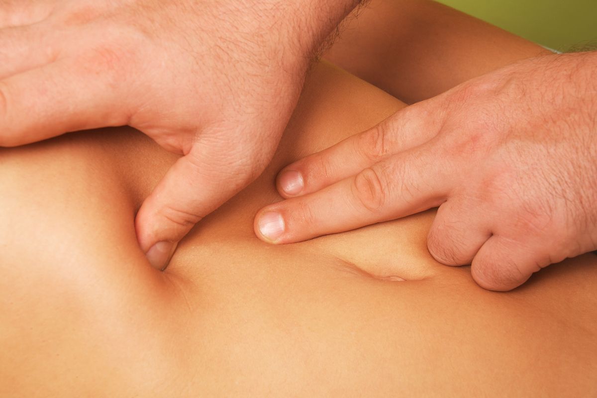 Hände führen eine Bauchmassage durch